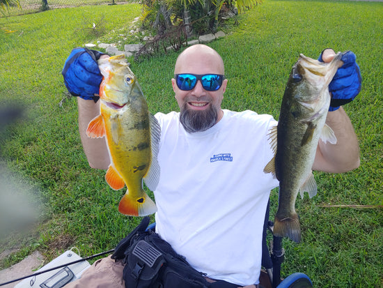 Evan holds a peacock bass and a large mouth bass