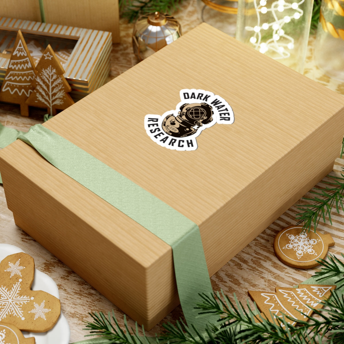 Wooden gift box with a green ribbon and 'Dark Water Research' logo on a festive background with cookies and lights.