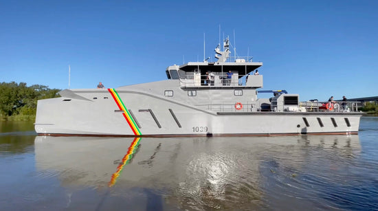 sleek gray offshore patrol vessel cruising out of harbor to begin patrol