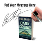 Book titled 'Dark Order' by Evan Graver with a hand holding a pen and signature overlay.