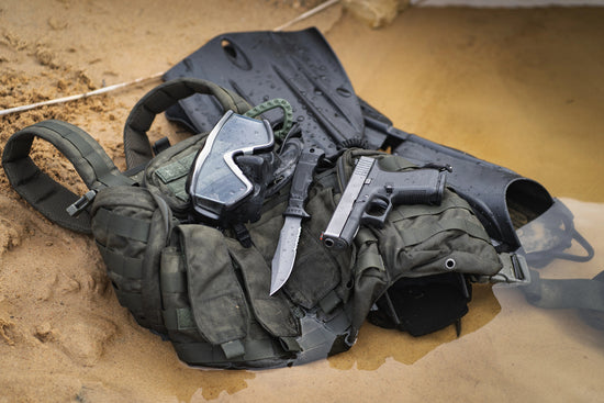  tactical vest with weapons and gear on a sandy surface